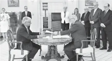  ??  ?? This handout photo from the Royal Commission shows Commission­er Justice Peter McClellan (left) and the Governor-General of Australia Peter Cosgrove at the signing ceremony and the release of the Final report of the Royal Commission into Institutio­nal...