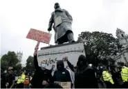  ??  ?? Protestors gather at the defaced statue of Winston Churchill earlier this month