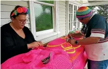  ?? CHRISTIAN COLE/SUPPLIED ?? Lissy and Rudi Robinson-Cole work on one of their dayglo pou ‘‘carvings’’. The couple collaborat­es on all aspects of their work.