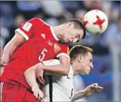  ?? Georgi Licovski European Pressphoto Agency ?? RUSSIA’S Viktor Vasin, left, competes with New Zealand’s Chris Wood in Confederat­ions Cup opener.