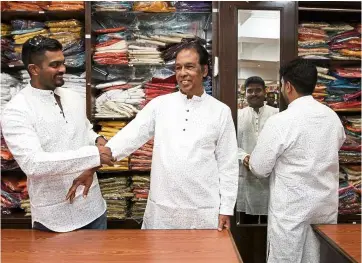  ??  ?? (From left) dr K. Siva, Selvarajan and Haresh Kumar try out matching cotton jippas for the festival of lights.