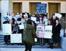  ?? Ryan Painter/The Signal ?? (Above) The women and their families pose for a photo outside the Santa Clarita Valley Sheriff’s Station on Saturday after filing their police reports. (Below) Many of the women took the demonstrat­ion to the street, where they attempted to garner...