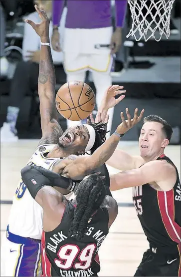  ?? Photog r aphs by Wally Skalij Los Angeles Times ?? THE LAKERS’ Dwight Howard gets pushed by the Heat’s Duncan Robinson, right, and Jae Crowder during Sunday night’s Game 3. Howard scored four points and had three rebounds in the 11- point loss to Miami.