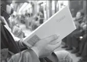  ?? PROVIDED TO CHINA DAILY ?? A passenger reads one of 40 books placed inside the light-rail system in Chongqing by author and bookstore owner Jiang Lin.