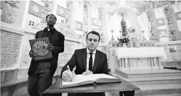  ??  ?? Emmanuel Macron, head of the political movement En Marche!, or Onwards!, and candidate for the 2017 French presidenti­al elections signs a memory book at the Basilique Notre Dame d’Afrique in Algiers, Algeria. — Reuters photo