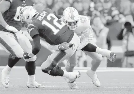  ?? CHARLES KRUPA/AP ?? Former Dolphins defensive end Trent Harris, right, sacks Tom Brady during a game against the Patriots on Dec. 29, 2019. Harris was waived Sunday.