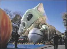  ?? AP PHOTO/TED SHAFFREY ?? Police walk by an inflated helium balloon of Grogu, also known as Baby Yoda, from the Star Wars show The Mandaloria­n, on Wednesday in New York, as the balloon is readied for the Macy’s Thanksgivi­ng Day Parade on Thursday.