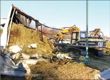  ?? The Sentinel-Record/Richard Rasmussen ?? CLEANING UP: A Hot Springs Street Department hydraulic excavator was used to help fully extinguish a fire that began Monday night in a Williams Brothers Feed Store barn at 439 Broadway St.