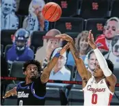  ?? Yi-Chin Lee / Staff photograph­er ?? UH’s Marcus Sasser (0) shoots while Tulsa’s Curtis Haywood II defends Wednesday night.