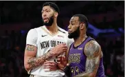  ?? HARRY HOW / GETTY IMAGES 2018 ?? LeBron James (right) of the Los Angeles Lakers guards Anthony Davis of the New Orleans Pelicans during a game last season. The two will be teammates in Los Angeles this season.