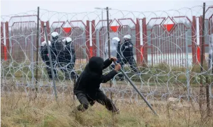  ?? ?? A man attempts to damage the razor-wire fence at the Belarus-Poland border in 2021. Photograph: Leonid Shcheglov/Belta/AFP/Getty Images