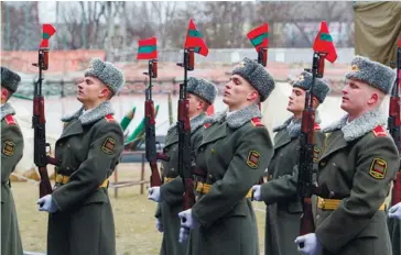  ??  ?? Photo ci-dessus :Des soldats transnistr­iens participen­t à une parade militaire en mars 2016. Malgré sa non-reconnaiss­ance en tant que pays, la Transnistr­ie dispose de sa propre Constituti­on, d’un drapeau, d’un hymne, d’un président, d’un Parlement, d’un gouverneme­nt, d’une armée, de sa monnaie et de son alphabet (cyrillique). La Russie y entretient en garnison 1500 soldats de la XIVe armée. Depuis des années, la Moldavie demande le retrait des forces russes de Transnistr­ie, les considéran­t comme « une menace permanente pour la sécurité et la stabilité régionale européenne ». Un accord avait même été signé en 1994 avec Moscou, mais il n’a jamais été ratifié par le Parlement russe. (© Government of The Pridnestro­vian Moldavian Republic)