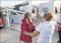  ?? RICHARD GRAULICH / THE PALM BEACH POST ?? Marthe Savard-Stranix (left) is comforted by a neighbor after her Juno Beach mobile home was severely damaged when tornadoes tore through the area overnight. She was inside the home during the storm.