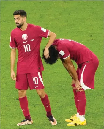  ?? ?? Qatar's Hassan Al-Haydos, left, and Akram Afif reacts after the World Cup group A soccer match between Qatar and Senegal, at the Al Thumama Stadium in Doha, Qatar, Friday, Nov. 25, 2022. Senegal won 3-1. (AP Photo/Ariel Schalit)