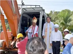  ??  ?? Danald (inside excavator) performs the earth-breaking at the compound of the old St Francis’ Church with Dennis beside him.