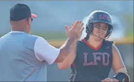  ??  ?? LFO junior Haley Stahl gets a high-five from head coach Tony Ellis following a homerun against Dade County last Monday. Stahl hit a solo shot and a grand slam and finished with six RBIs in the game.