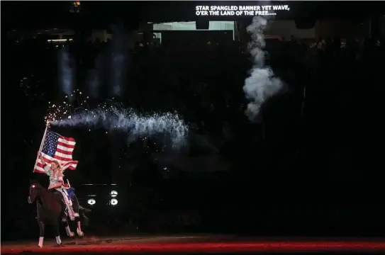  ?? Elizabeth Conley / Houston Chronicle ?? Fireworks erupt from a flag pole during the singing of the national anthem on the last day of the Houston Livestock Show and Rodeo last Sunday. This year’s attendance record crushed the 2013 tally by 100,000 attendees.