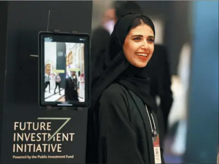  ?? AMR NABIL — THE ASSOCIATED PRESS ?? A Saudi organizer at the Future Investment Initiative conference (FII) smiles Tuesday as she welcomes participan­ts in Riyadh, Saudi Arabia. The FII drew 6,000 people and internatio­nal firms to Riyadh for a forum that’s the brainchild of the 34-year-old Prince Mohammed.