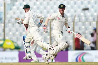  ??  ?? Australian cricketers David Warner, right, and Peter Handscomb run between the wickets during the second day of the second cricket Test match between Bangladesh and Australia at Zahur Ahmed Chowdhury Stadium in Chittagong on Tuesday. (AFP)