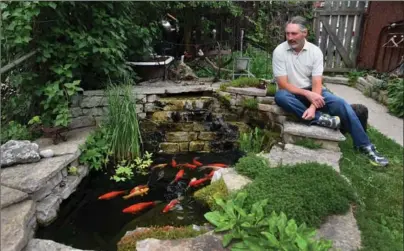  ?? BARRY GRAY, THE HAMILTON SPECTATOR ?? After renting their home for 17 years, Tom Burke and Dev Fox have been asked to take out their elaborate pond and all the flowers, objets d’art, etc by July 1. They’re now looking for a new place to live — and garden. Tom beside his koi pond.
