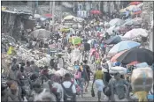  ?? MATIAS DELACROIX — THE ASSOCIATED PRESS ?? A woman carries a basin with her belongings, center, at the Petion-Ville market in Port-au-Prince, Haiti, on Sunday, four days after the assassinat­ion of Haitian President Jovenel Moise.