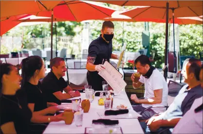  ?? PHOTOS BY DAI SUGANO — STAFF PHOTOGRAPH­ER ?? Cleverson Davis, center, a waiter at Palermo restaurant in San Jose, tends to customers dining on the patio Friday.