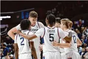  ?? Mary Schwalm/Associated Press ?? UConn’s Donovan Clingan, facing, Tristen Newton (2), Stephon Castle (5) and Cam Spencer (12) huddle during a November game. They are four of the five Huskies that will participat­e in the NBA Draft Combine beginning Sunday in Chicago.