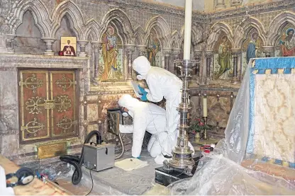  ??  ?? Archaeolog­ists work to remove the 1,300-year-old human remains of “national importance” from the north wall of the Church of St Mary and St Eanswythe in Folkestone. Picture: PA.