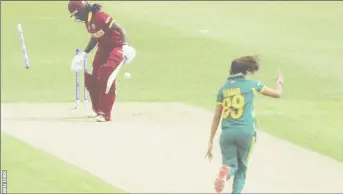  ??  ?? West Indies women’s team captain Stafanie Taylor looks back to see her off stump sent cartwheeli­ng by Shabnim Ismail.