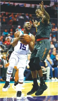  ?? AP PHOTO/JASON E. MICZEK ?? Charlotte Hornets guard Kemba Walker tries to get around Atlanta Hawks guard Trae Young during the first half of Tuesday’s game in Charlotte, N.C.