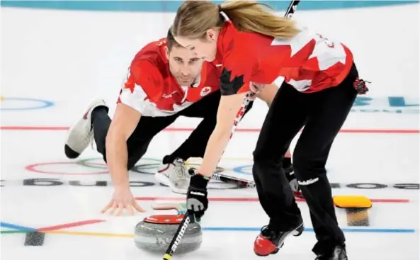  ??  ?? Kaitlyn Lawes and John Morris get down to business in the mixed doubles gold-medal game against Switzerlan­d at the Olympic Winter Games in Gangneung, South Korea, on Tuesday. The Canadian duo dominated, winning 10-3. Nathan Denette/The Canadian Press