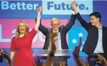  ?? RICK RYCROFT AP ?? Labor Party leader Anthony Albanese (center) celebrates with his son Nathan (right) and his partner Jodie Haydon in Sydney.