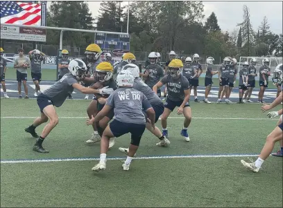  ?? PHOTOS BY JUSTIN COUCHOT — ENTERPRISE-RECORD ?? Pleasant Valley outside linebacker and defensive captain Gabe Ponce, center, helps wrap up the running back during a walk-through practice on Friday at Pleasant Valley High in Chico.