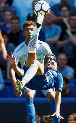  ??  ?? Going acrobatic: Chelsea’s Pedro attempts an overhead kick in front of Everton’s Mason Holgate in the English Premier League match at Stamford Bridge yesterday. Chelsea won 2- 0. — Reuters