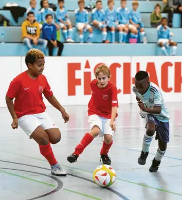  ?? Foto: Marcus Merk ?? Dass der TSV Fischach (rote Trikots) gegen den FC Bayern München spielt, kommt nicht alle Tage vor. Deshalb war es für die Jungs aus der Region eine besondere Gelegenhei­t, dass viele bekannte Vereine zum Topstar-Cup nach Fischach anreisten. Auf der Tribüne beobachtet der Nachwuchs des TSV 1860 München das Geschehen.