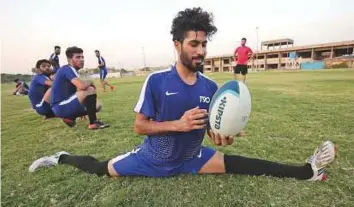  ?? AFP ?? Haidar Abbas, a player of Iraq’s first national rugby team, holds a ball during a practice session on a pitch provided for free by Baghdad University in the capital, on Saturday.