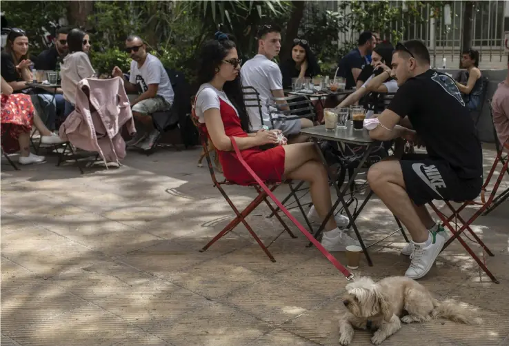  ??  ?? Människor hänger på ett kafé i Aten efter att Grekland börjat tillåta sittande gäster för första gången på ett halvår. Nu hoppas landet att turisterna återvänder till sommaren.