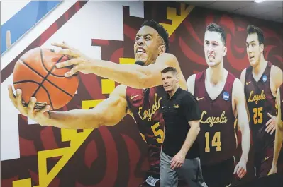  ?? ERIC GAY / AP ?? Loyola-chicago coach Porter Moser walks past a picture of his players after a practice session for the Final Four on Thursday in San Antonio. Joining Loyala-chicago in the Final Four today are Michigan, Villanova and Kansas.