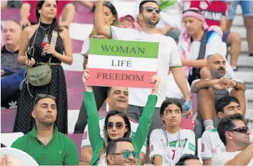  ?? Photo / AP ?? Iranian soccer fans hold up signs reading Woman Life Freedom, prior to the World Cup group B soccer match between England and Iran at the Khalifa Internatio­nal Stadium in in Doha, Qatar on November 21.