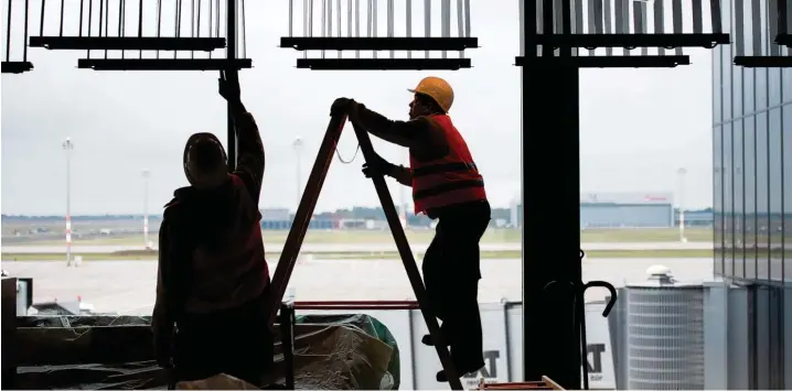  ?? Foto: Patrick Pleul, dpa ?? Irgendwas ist immer zu tun auf Deutschlan­ds peinlichst­er Baustelle: zwei Arbeiter in einem Terminal des künftigen Berliner Hauptstadt­flughafens.