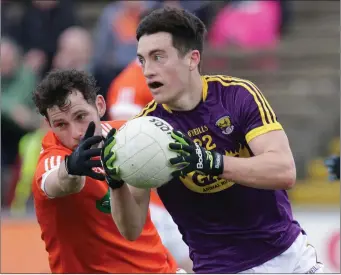  ??  ?? Wexford substitute Robert Frayne on the move, with Armagh’s Oisín Mac Iomhair in hot pursuit.