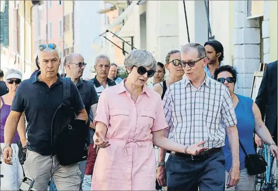  ?? ANTONIO CALANNI / AFP ?? La premier británica, Theresa May, y su marido pasean por Desenzano del Garda, en el norte de Italia, donde están pasando sus vacaciones