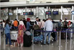  ?? (Azad Lashkari/Reuters) ?? PASSENGERS LINE UP at the check-in counters at Erbil Internatio­nal Airport in Iraq yesterday.