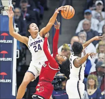  ?? [STEPHEN DUNN/THE ASSOCIATED PRESS] ?? Connecticu­t’s Napheesa Collier blocks a shot by Louisville’s Dana Evans during the Huskies’ 76th straight home win.