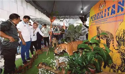  ?? BERNAMA PIC ?? Water, Land and Natural Resources Minister Dr Xavier Jayakumar (second from left) looking at an exhibit at the pre-launch of the ‘Save our Malayan Tiger Campaign’ in Kuala Lumpur yesterday.