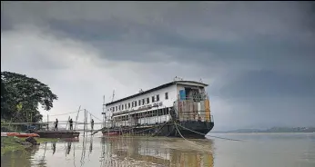  ?? PTI ?? An NDRF boat on the bank of Brahmaputr­a as dark clouds cover the sky in Guwahati on Thursday.
