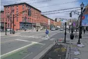  ?? AP PHOTO/SETH WENIG ?? A pedestrian crosses the street Feb. 22 at the intersecti­on of Washington and 5th streets in Hoboken, N.J.