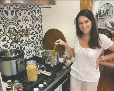  ?? (Courtesy Photo/William Nagle) ?? Erika Navarrete Nagle, a television producer in Denver, Colo., prepares a meal Sunday for her family in Denver. Before she began quarantini­ng in late March, the 33-year-old had never cooked chicken. “I was a mess in the kitchen,” she says. “I grew up in a Cuban family with a mother and sister who always cooked for me. You’d think I picked up a thing or two, but I’ve always been a workaholic and I never made time nor had the desire to cook.”