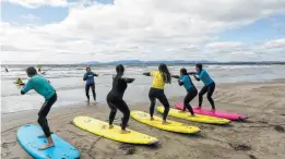  ??  ?? A surfing class at Rossnowlag­h, Ireland. On any given day, throngs of learners brave the waves in group classes across Ireland.