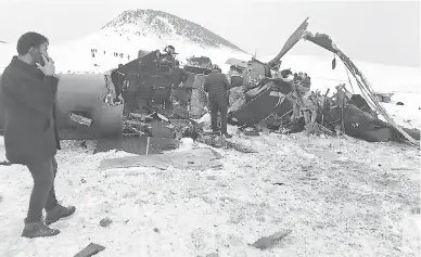  ?? — Gambar AFP ?? TERHEMPAS: Anggota penyelamat memeriksa bangkai helikopter tentera yang terhempas di timur Bitlis kelmarin.